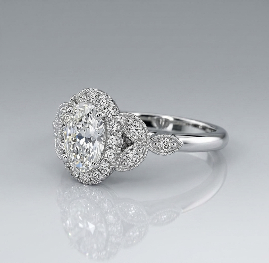 Angled rear profile of an oval diamond engagement ring highlighting the vintage-inspired leaf motif shoulders with delicate milgrain detailing.