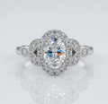 Top-down view of a vintage-inspired 2 carat oval lab grown diamond ring featuring a sparkling halo and symmetrical floral diamond side stones.