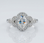 Top-down view of a vintage-inspired 2 carat oval lab grown diamond ring featuring a sparkling halo and symmetrical floral diamond side stones.