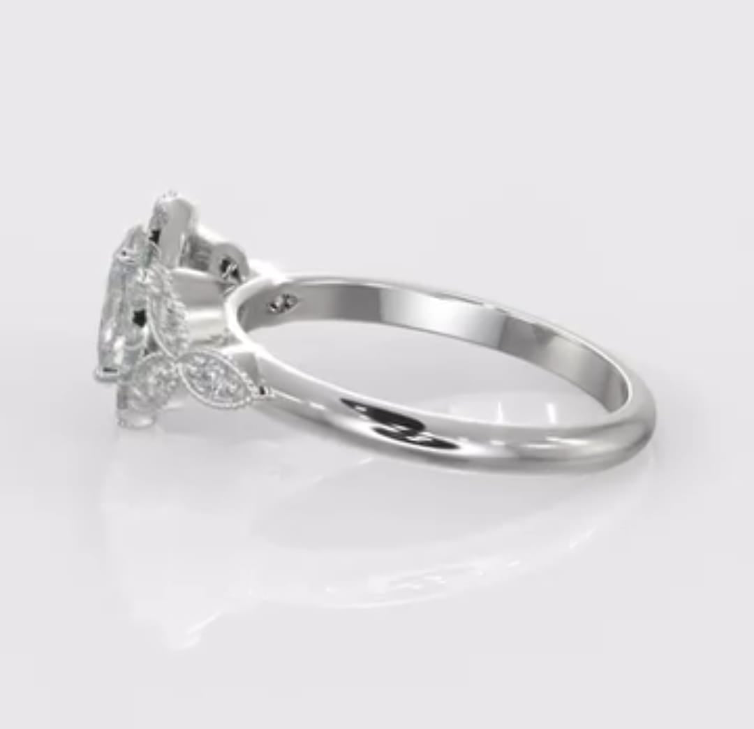 Angled side view of an oval cut diamond halo ring emphasizing the smooth lower shank gently curving into the detailed milgrain diamond leaf shoulders.