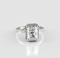Straight-on top view of a breathtaking 3 carat radiant cut lab created diamond surrounded by a sparkling halo on a polished white metal band.