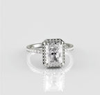 Straight-on top view of a breathtaking 3 carat radiant cut lab created diamond surrounded by a sparkling halo on a polished white metal band.