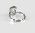 Low angle profile showcasing the intricate diamond bridge detailing and secure, elevated basket setting of the radiant cut engagement ring.