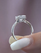 Side profile view of a 2 carat princess cut lab grown diamond ring displaying a delicate hidden halo and pavé diamond detailing on a white metal band.