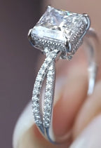 Close-up angled view highlighting the intricate diamond-encrusted gallery basket and the gracefully twisted pavé bands supporting the princess cut center stone.