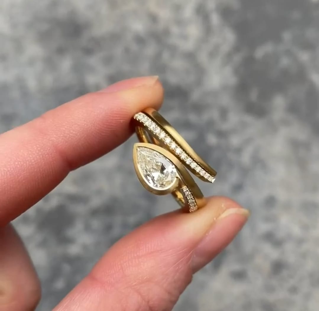 Top view of 2 CT Pear Cut Lab Grown Diamond Ring with bezel setting and nesting pave diamond band in yellow gold.