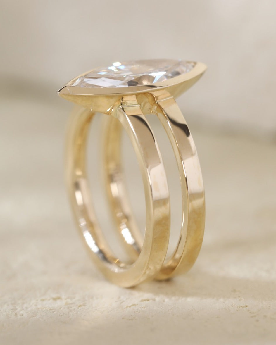 Side profile of a gold lab grown diamond ring featuring a sleek bezel setting and a modern double band.