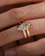 Close-up of an East-West bezel set lab grown diamond engagement ring worn on a finger.