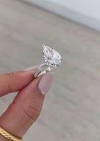 Side profile of a 4 carat pear cut lab grown diamond engagement ring with a sweeping pavé band.