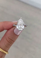 Front view of a 4 carat pear cut lab diamond ring showcasing the curved diamond band.