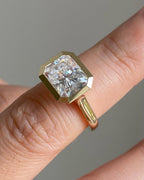 Side perspective showing the smooth yellow gold band and bezel setting of a 3 carat radiant lab diamond ring.