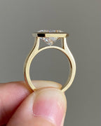 Open profile view showing the elevated bezel setting and 14K gold stamp inside the band of a radiant diamond ring.