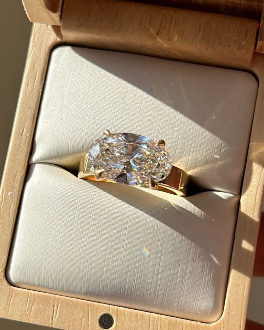 2 CT oval lab created diamond solitaire ring set horizontally in a luxury wooden ring box