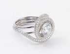 Perspective view of round lab diamond statement ring featuring swirl halo and pave band