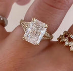 Close-up of 4 CT radiant cut lab diamond ring with double claw prongs on finger.