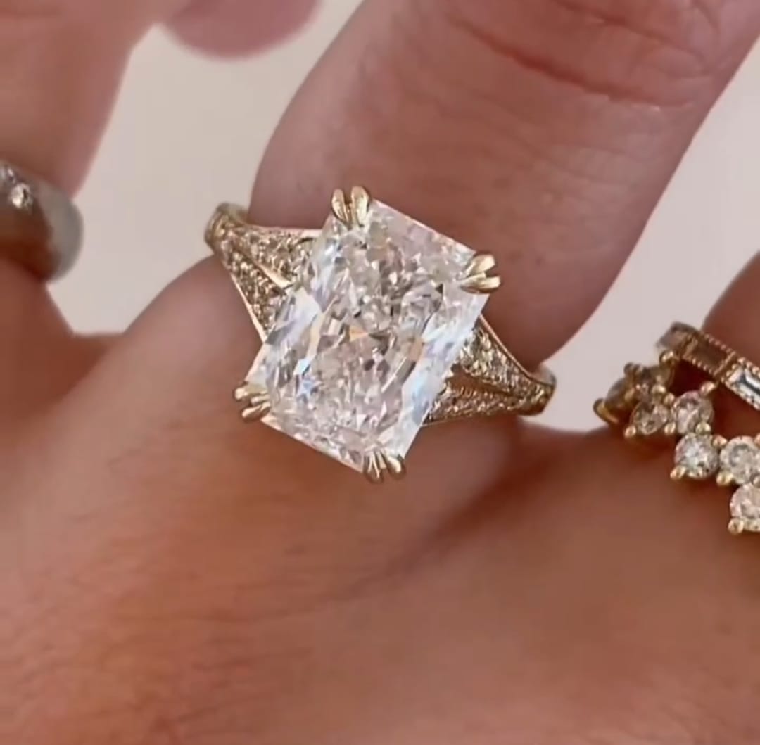 Close-up of 4 CT radiant cut lab diamond ring with double claw prongs on finger.