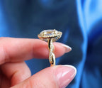 Side profile of 3 carat oval lab grown diamond halo engagement ring with pavé twisted band.