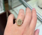 Top view of 3 CT oval cut lab grown diamond halo engagement ring on hand.