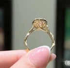Inner view showing sculpted petal gallery basket under an oval lab diamond ring.