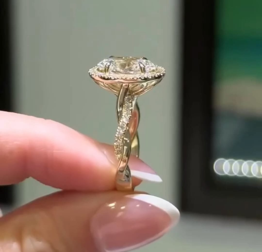 Macro side shot showcasing the pavé-set twisted band on a yellow gold halo ring.