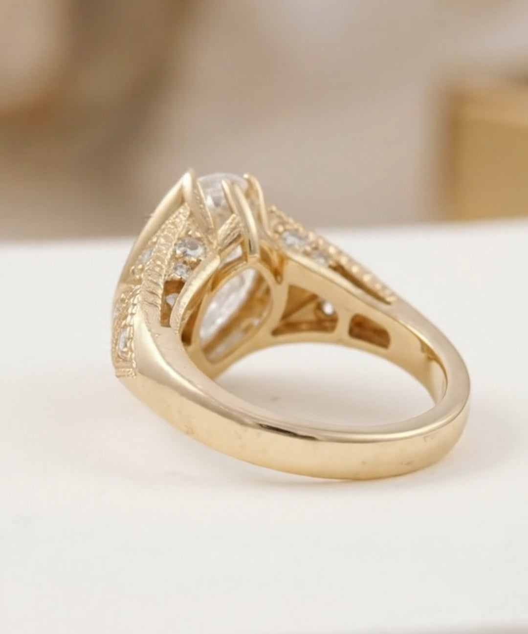 Side and band view of a yellow gold marquise engagement ring showing the tapered band and detailed under-gallery.