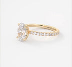 Angled shot displaying the brilliance of a 2 carat oval lab diamond in a yellow gold setting.