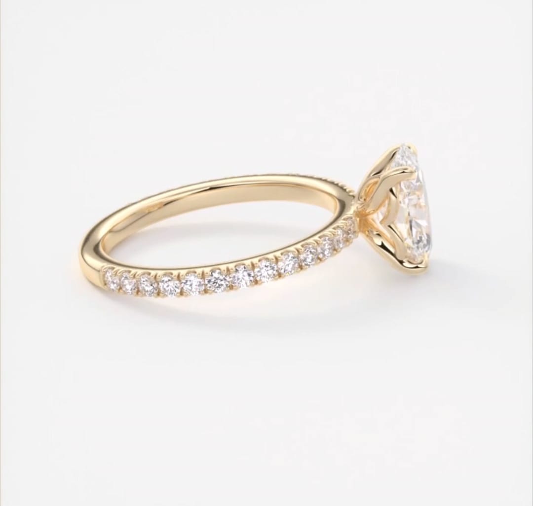 Side profile view showing delicate pave band alignment on a yellow gold oval engagement ring.