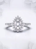 Front view of a 2 carat pear cut lab grown diamond engagement ring with floral sunburst halo in white gold.