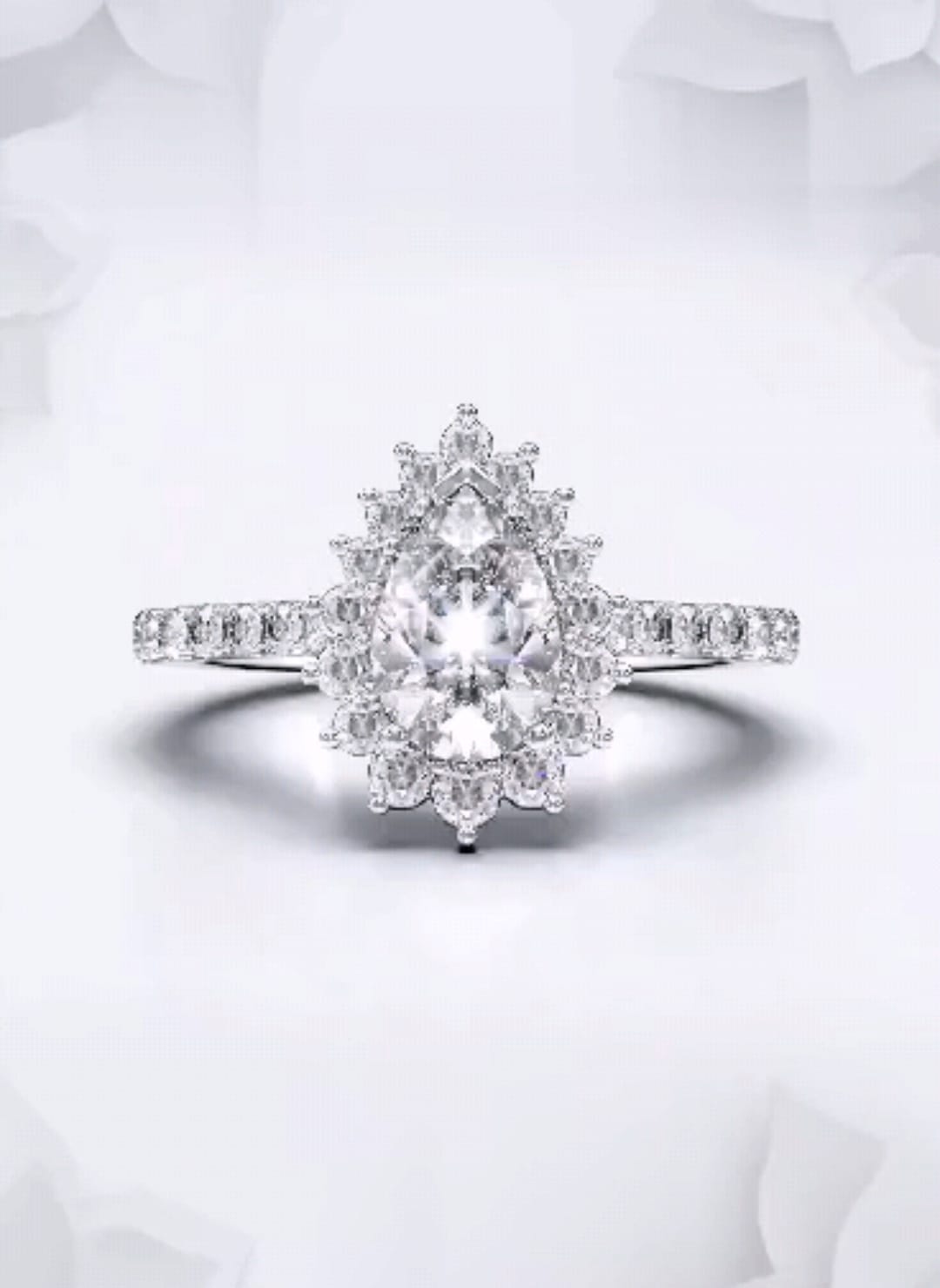 Front view of a 2 carat pear cut lab grown diamond engagement ring with floral sunburst halo in white gold.