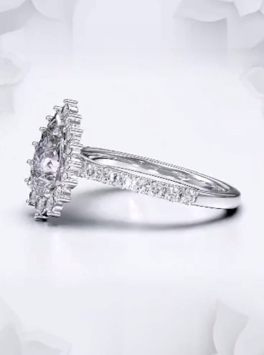 Three-quarter view of a pear shaped lab grown diamond ring featuring a delicate pavé accent band.