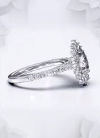 Angled shot highlighting the brilliant facets of a 2 carat pear cut lab diamond ring with a floral halo.