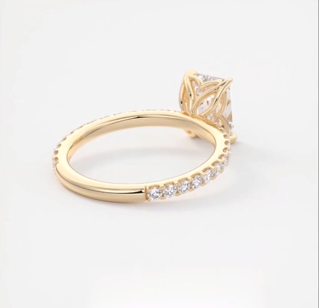 Profile angle focusing on the floral petal cathedral setting of a yellow gold engagement ring.