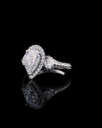 Perspective view showcasing the elongated pear cut diamond, halo surround, and reflection