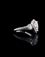 Side view showing the detailed joinery between the pear center halo and trillion accent diamond