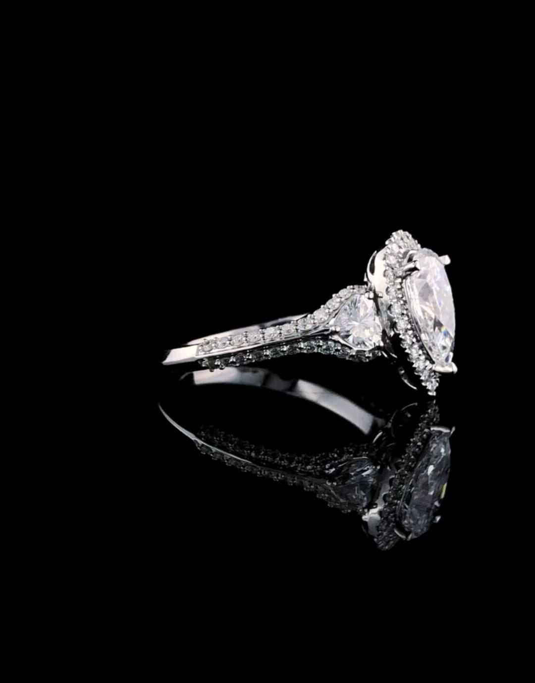 Side view showing the detailed joinery between the pear center halo and trillion accent diamond