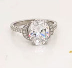 Top front perspective of 3 carat oval lab grown diamond ring showcasing crescent side frames and sparkling facets