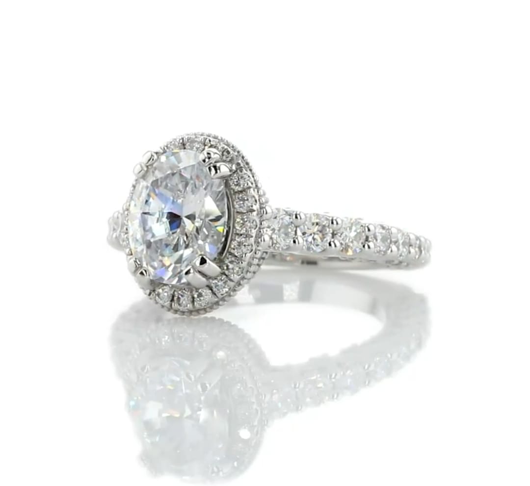Three-quarter view of a sparkling 2 carat oval lab grown diamond with a surrounding halo and diamond band.
