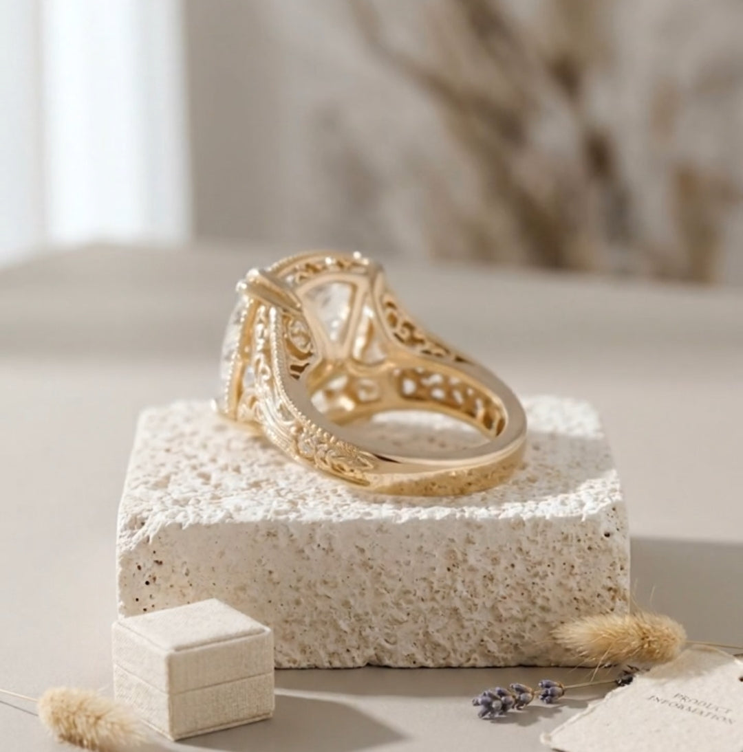 Rear angle view of a yellow gold engagement ring showing intricate filigree cut-outs on the under-gallery and band.
