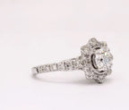 Angled view showcasing the center round diamond with milgrain bezel and floral halo