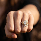 On-hand perspective shot of 2 CT pear lab grown diamond bezel cluster engagement ring.