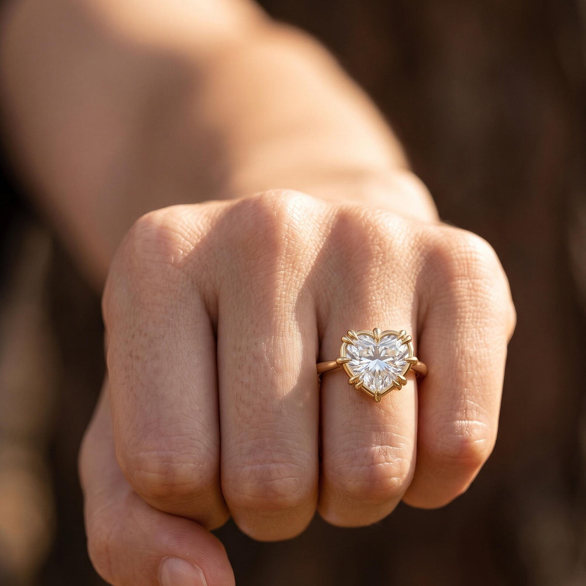 On-finger view of a 3 carat heart cut lab grown diamond solitaire engagement ring in yellow gold.