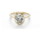 Front view of a 2 CT oval cut lab grown diamond solitaire engagement ring in a solid yellow gold full bezel setting.
