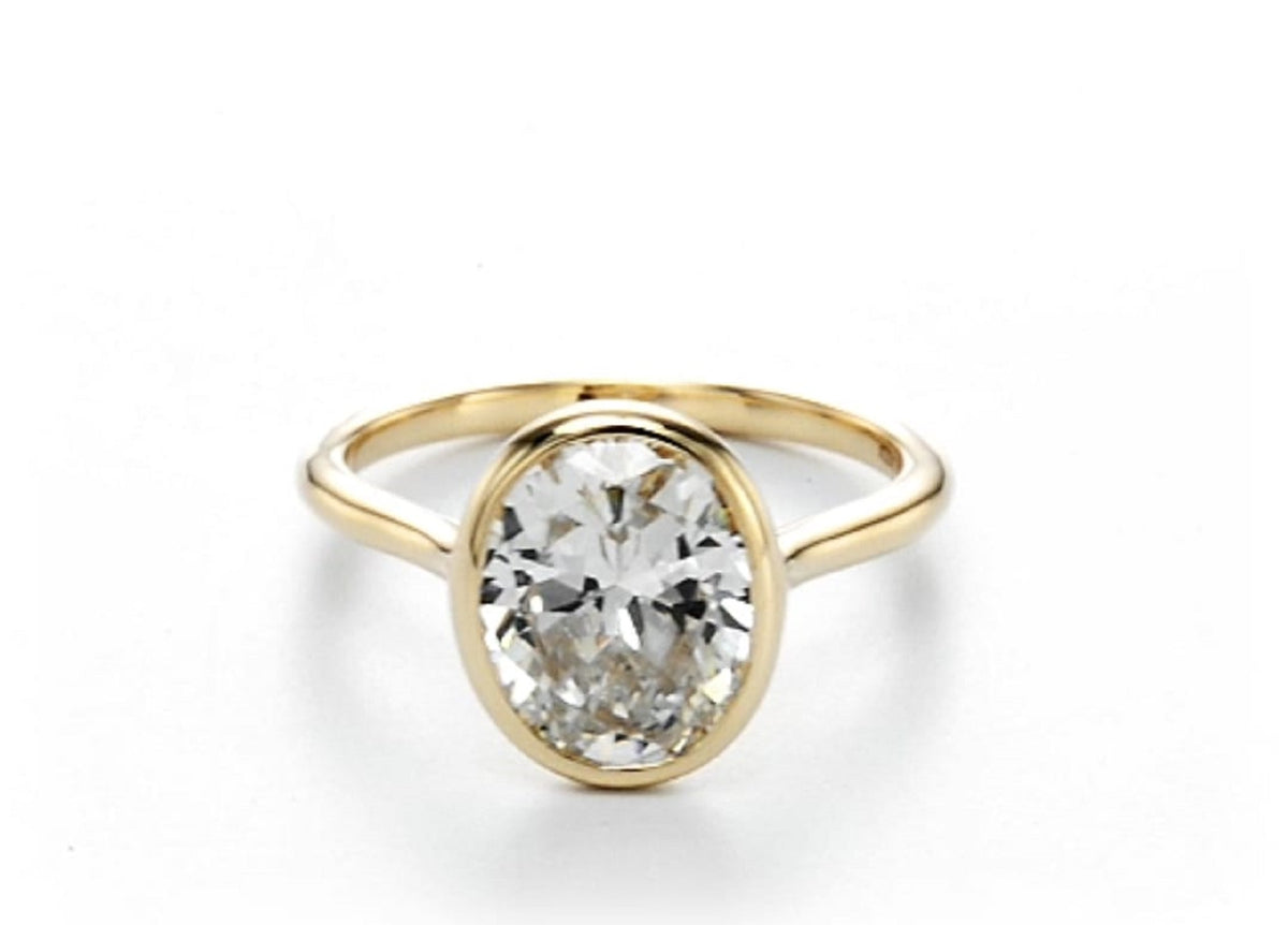 Front view of a 2 CT oval cut lab grown diamond solitaire engagement ring in a solid yellow gold full bezel setting.