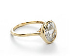 Side view showing the inner band engraving and sleek bezel head holding a 2 carat oval lab diamond.