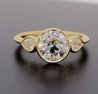 Front top view showing a 3 CT round bezel-set lab diamond ring flanked by two pear side diamonds.