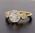 Angled view of a modern 3 carat round cut lab diamond three stone ring in bezel setting.