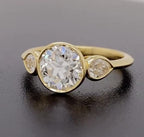 Angled view of a modern 3 carat round cut lab diamond three stone ring in bezel setting.