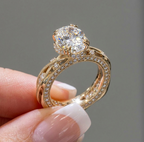 Close-up angled view of an oval engagement ring highlighting the split claw prongs and vintage-inspired diamond band.