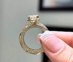 Straight-on front view of a vintage-style yellow gold engagement ring featuring a brilliant oval center stone and geometric band details.
