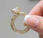 Detailed side view of a yellow gold engagement ring showing a hidden diamond halo wrap and milgrain pave side profile.